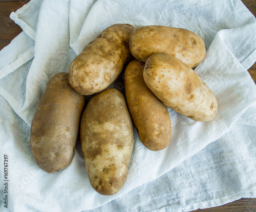 still life 6 potatoes piled on a white cloth viewed from above