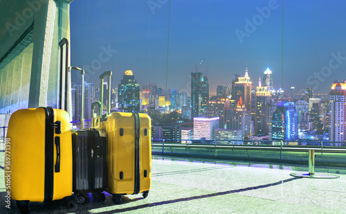 traveling luggage in airport terminal with night scene of high building in city photo