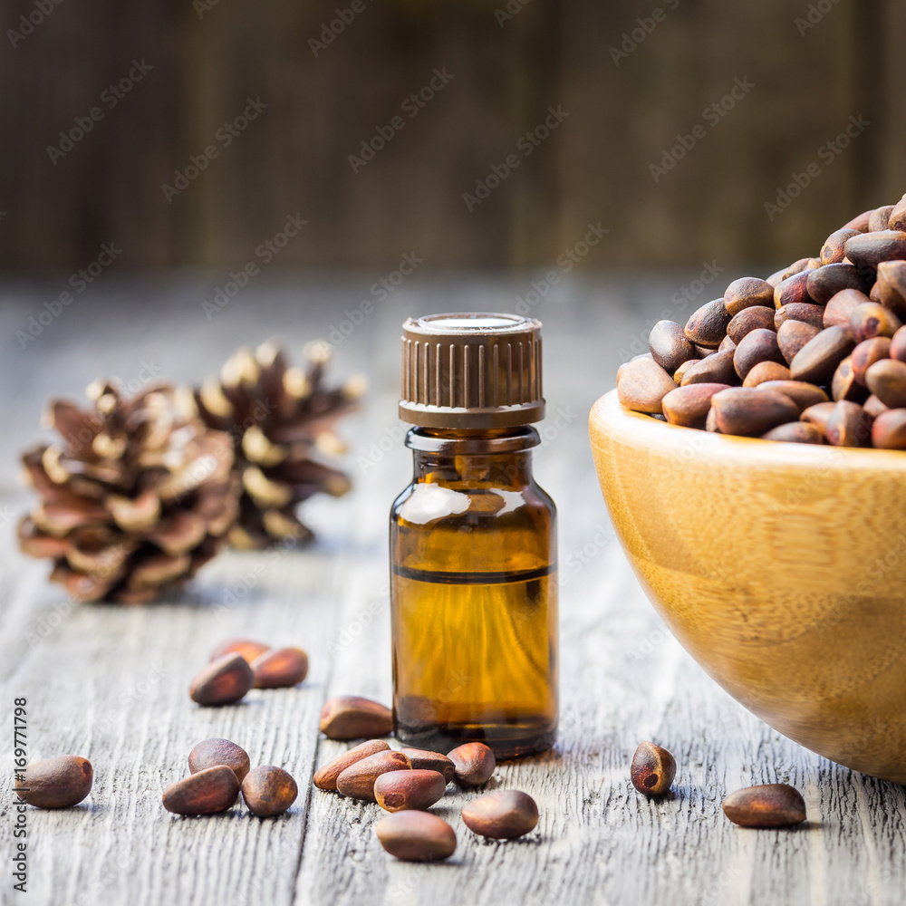 Pine nuts oil, whole pine nuts on wooden background. Selective focus, copy space. Pine nuts oil, whole pine nuts on wooden background. Selective focus, copy space.