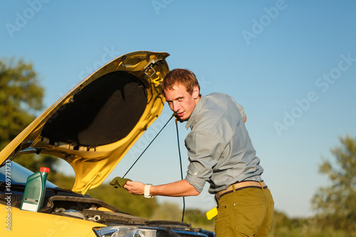 Man checks the oil level photo