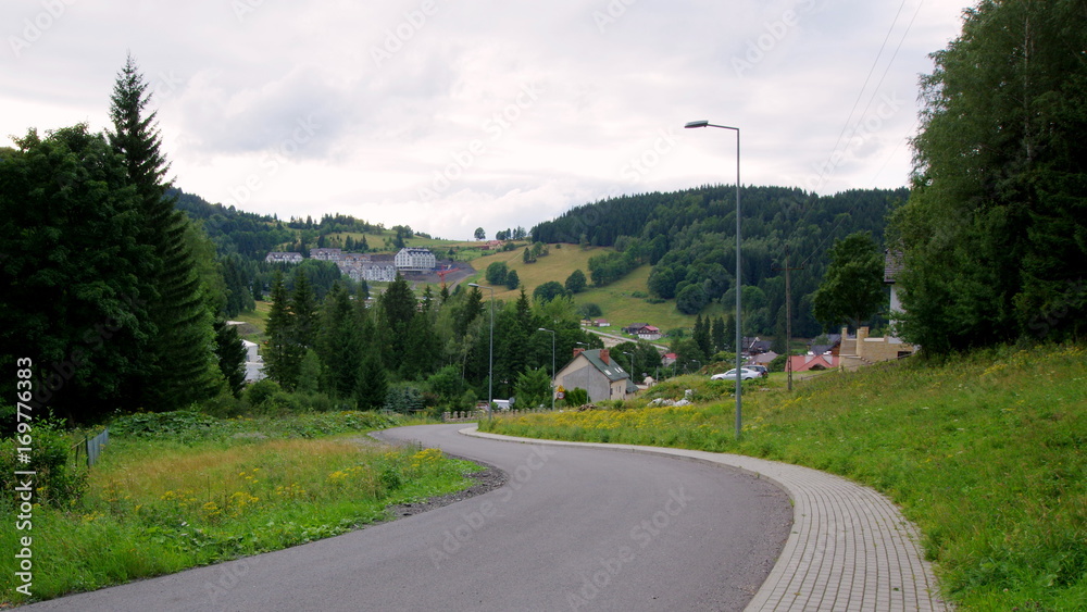 Kręta, asfaltowa droga w górskiej polskiej wiosce - podróż po Dolnym Śląsku