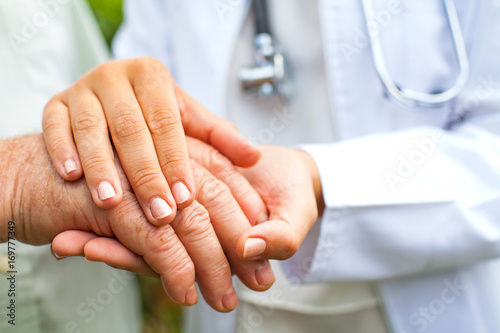 Doctor holding trembling hand photo