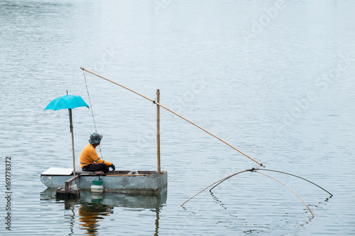 Asian fisherman fishing in the river morning.