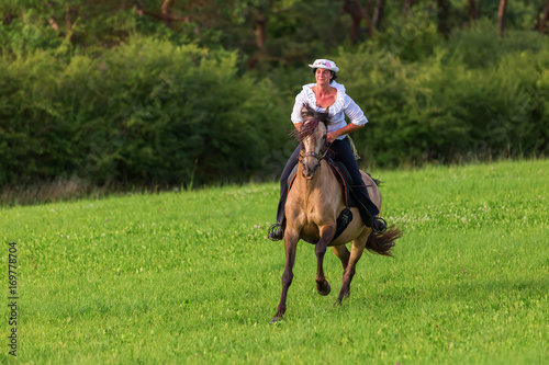 mature woman riding an Andalusian horse