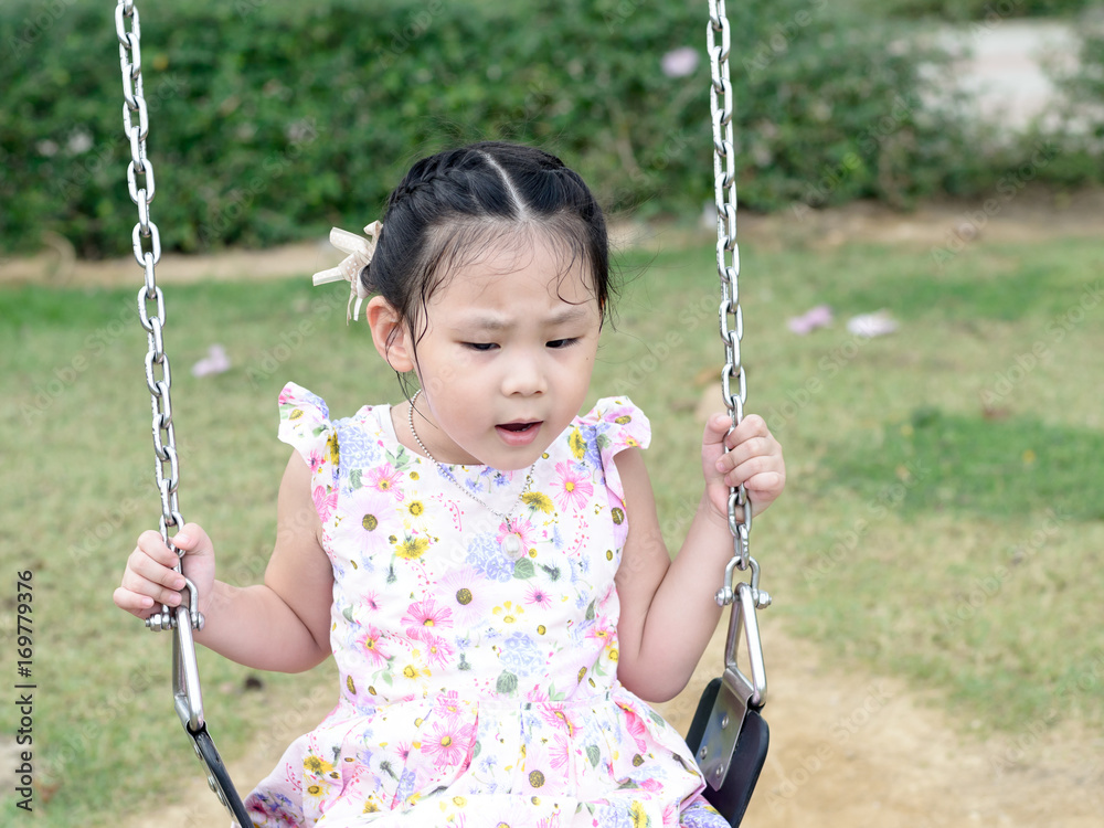 Adorable girl having fun on a swing in playground. Adorable girl having fun on a swing in playground.