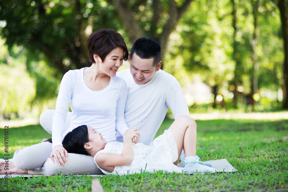 Young happy Asian family spending time together at the park. Young happy Asian family spending time together at the park.