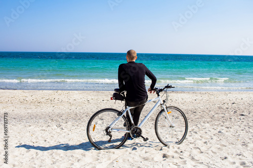Bicycle rider relaxing on the beach in good weather  © serejkakovalev