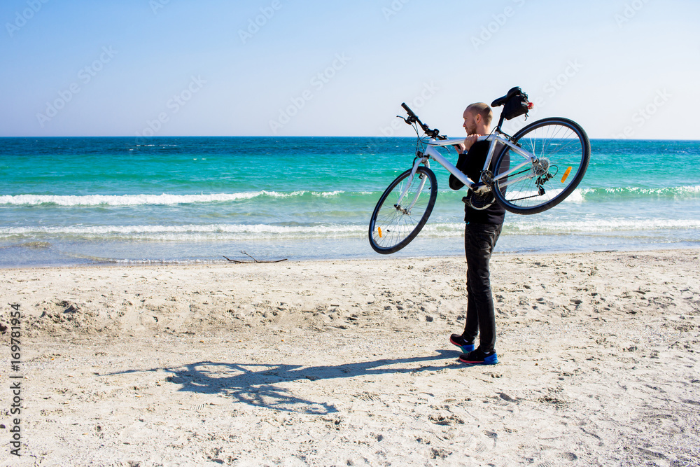 Fototapeta premium Bicycle rider relaxing on the beach in good weather