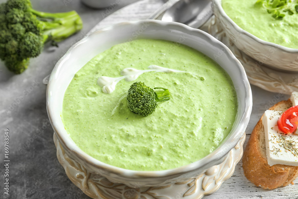 Bowl with delicious broccoli soup on wooden tray Bowl with delicious broccoli soup on wooden tray