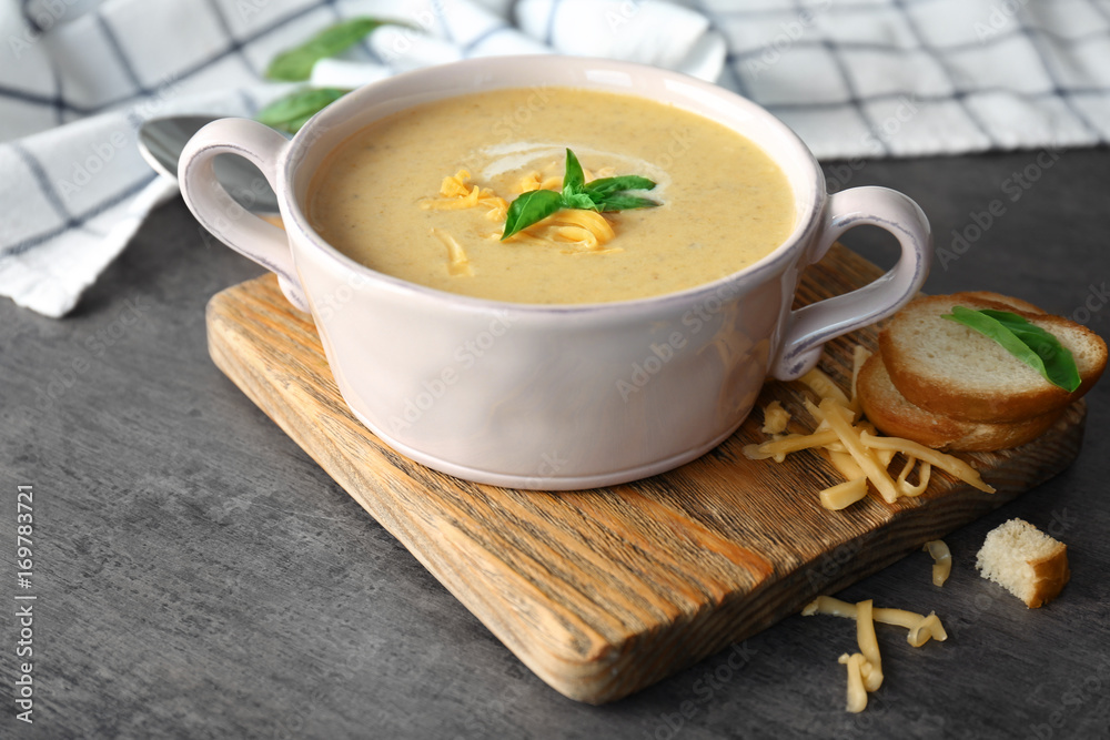 Broccoli cheddar soup in bowl on wooden board Broccoli cheddar soup in bowl on wooden board