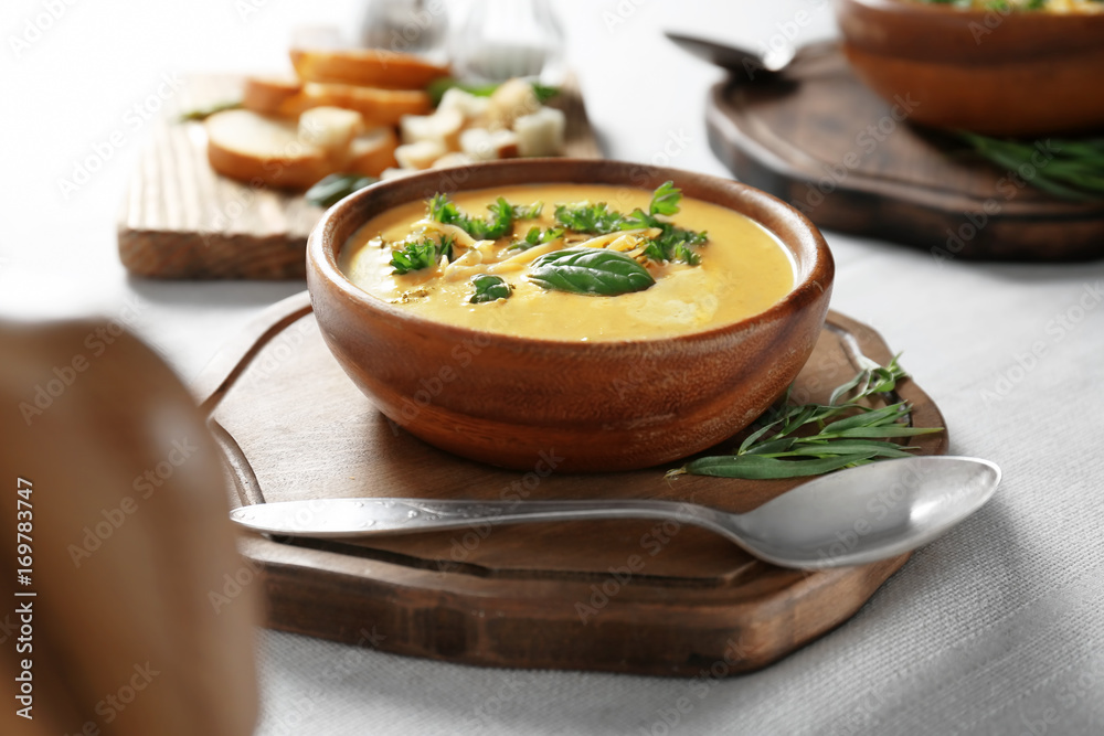 Bowl with broccoli cheddar soup on wooden board Bowl with broccoli cheddar soup on wooden board
