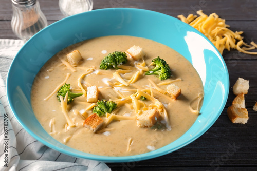 Plate with broccoli cheddar soup on table