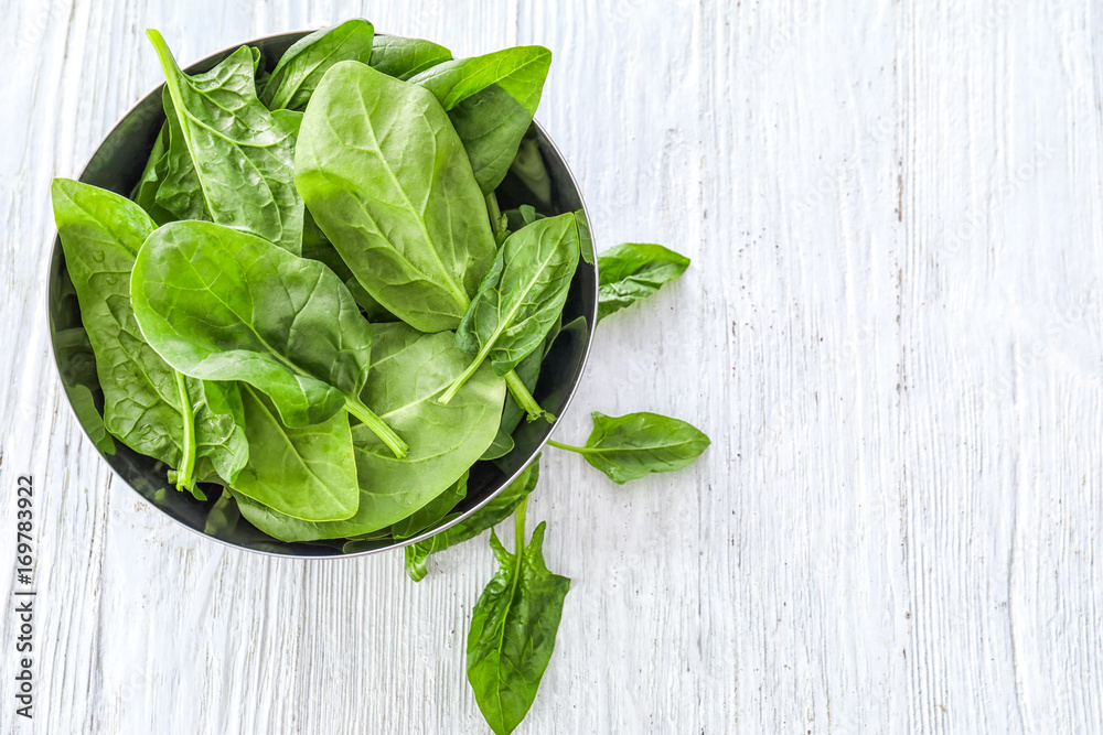 Bowl with fresh spinach leaves on table Bowl with fresh spinach leaves on table
