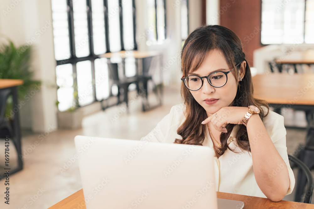 Asian young business freelance woman concentrate working online business with laptop and cell phone in cafe shop. Working, Success, concentrate concept.