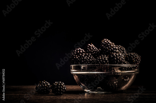 Fresh Ripe Juicy Blackberries in a plate on black background