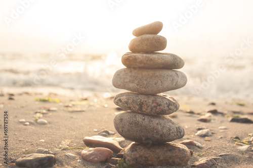Stones balance on beach in sunrise light 