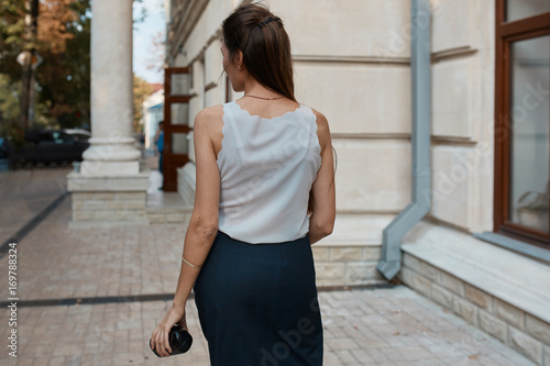Beautiful brunette young woman walking through the streets of Old City. Fashion concept