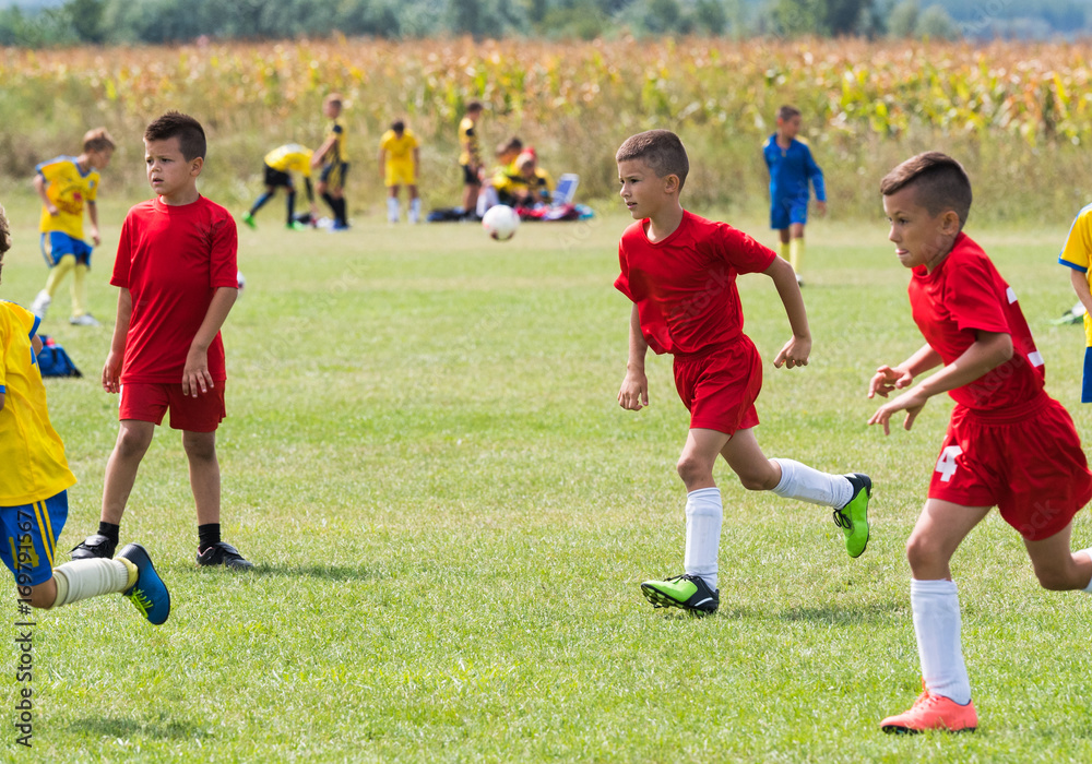 Kids soccer football - children players match on soccer field Kids soccer football - children players match on soccer field