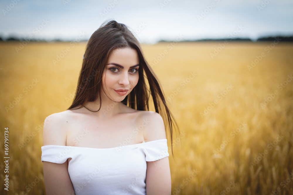 Beautiful woman girl looking at camera. close-up to very beautiful girl with amazing green eyes red lips and attractive face. cute amazing portrait in the field of wheat. birthmark on the face