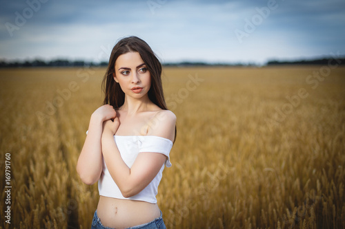 woman is walking in golden field of wheat