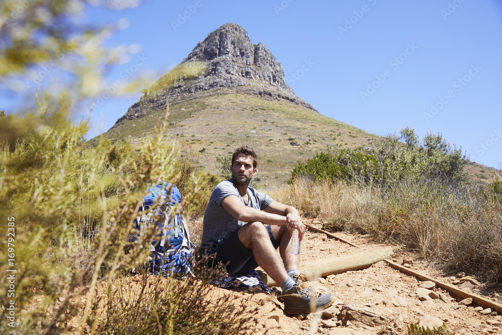 Mountain trail hiker taking break, looking away
