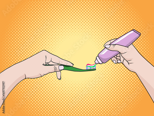 Hands of a woman squeezing toothpaste on a toothbrush