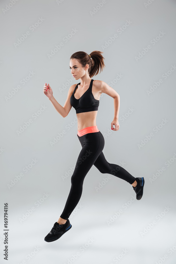 Full length image of a sports woman running in studio Full length image of a sports woman running in studio