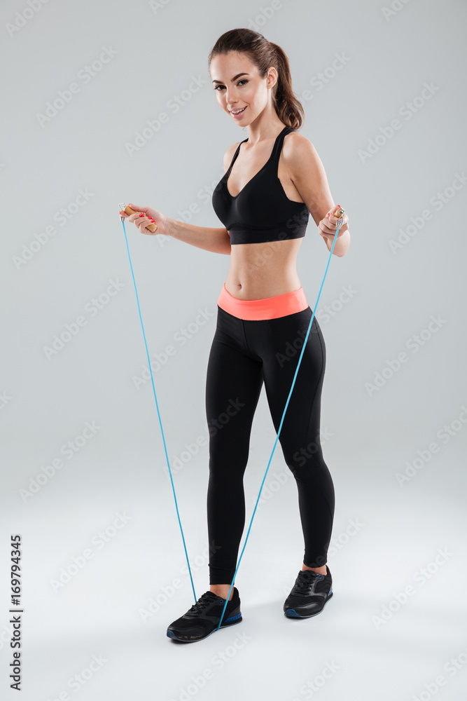 Full length image of a smiling fitness woman doing exercise Full length image of a smiling fitness woman doing exercise