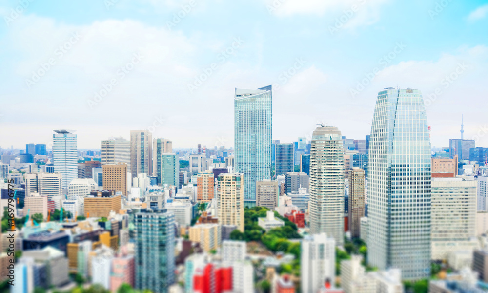 Business and culture concept - panoramic modern city skyline bird eye aerial view from tokyo tower under dramatic morning blue cloudy sky in Tokyo, Japan. Miniature Tilt-shift effect