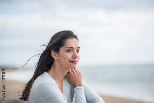 Portrait of a beautiful young brunette woman on the beach