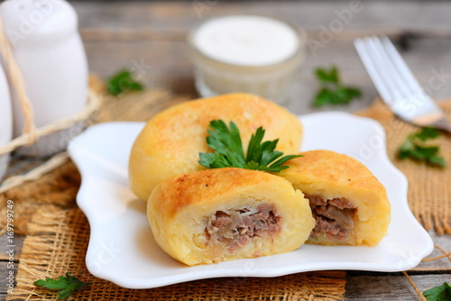 Fried ground beef and potato patties on a white plate. How to make potato patties stuffed with beef. Rustic style. Closeup
