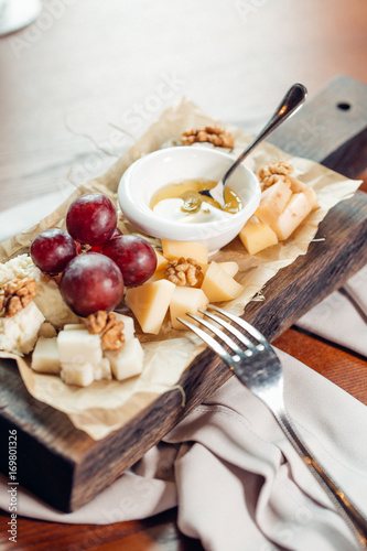 Assorted cheeses with honey and nuts photo