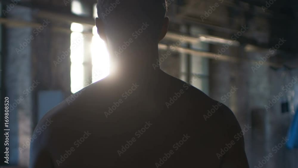 Follow-up Shot of Muscular Shirtless Man Entering Gym in Slow Motion. He's Ripped, Confident and Ready to Start His Training Day. Shot on RED EPIC-W 8K Helium Cinema Camera.