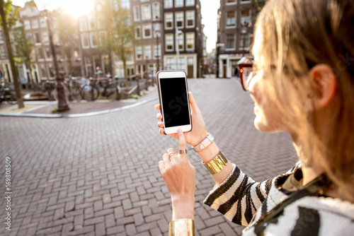 Photography Holding a smart phone with empty screen to copy paste outdoors on the street in
