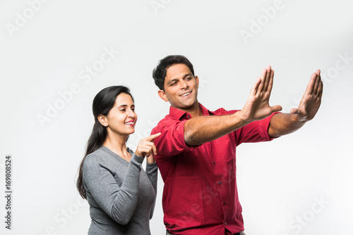 Konstfotografi stock photo of Indian smart and cheerful / happy couple indoor, husband composin
