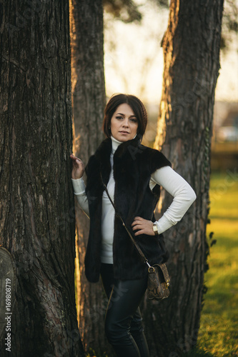 A young mother walks through the park in the golden autumn