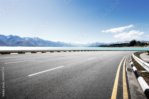 empty road with beautiful lake in blue sky