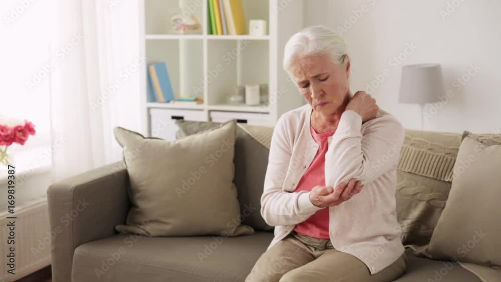 senior woman suffering from pain in hand at home senior woman suffering from pain in hand at home