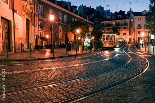 Photo Traditional yellow tram at the old night streets of Lisbon