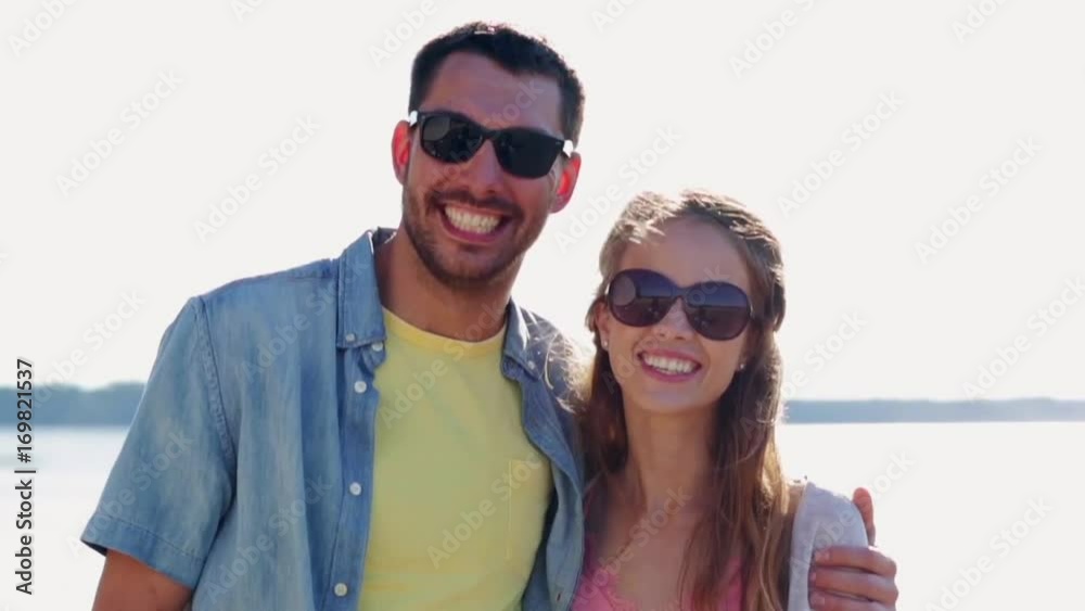 happy couple in sunglasses hugging over sea happy couple in sunglasses hugging over sea