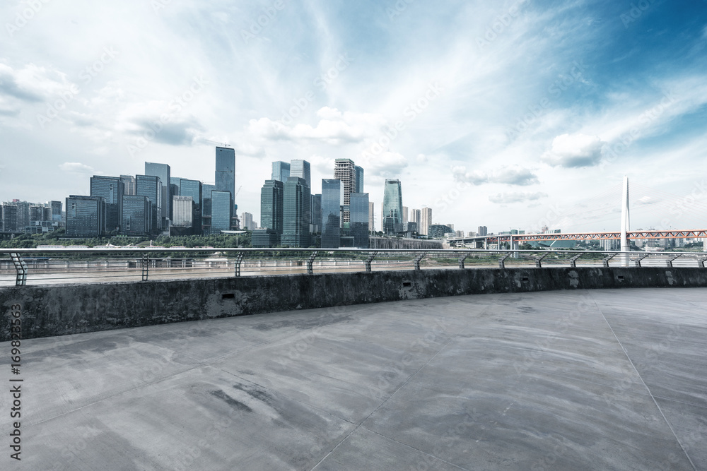 empty concrete road with cityscape of modern city in blue sky