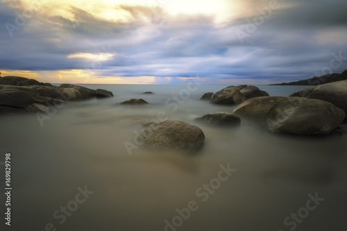 Beautiful and sea water long exposure with rock in sunset