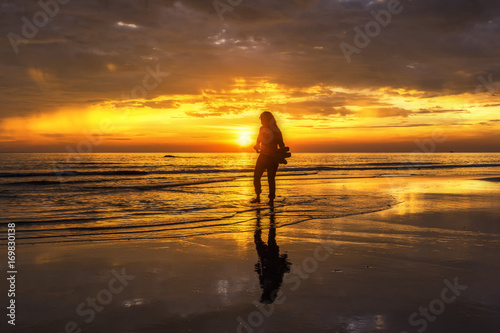 seascape in sunset beautiful light and sky with silhouette sunset with girl walking on beach at mae ramphueng beach,Rayong Province,Thailand © uaychai