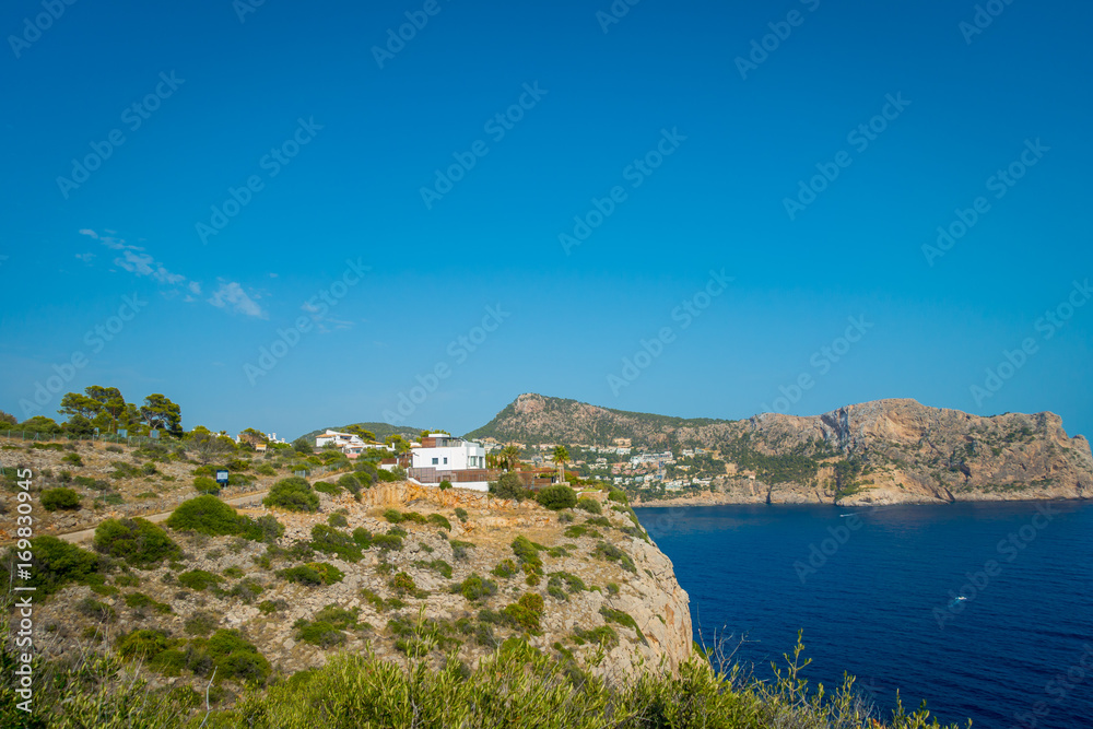 Beautiful view of Mallorca balearic islands, with some buildings in the mountain, in a beautiful blue sky Spain