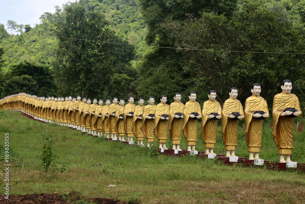 Obraz premium Simulated statue that's like a monk holding a almsbowl lined up beautiful at the temple in Myanmar. 