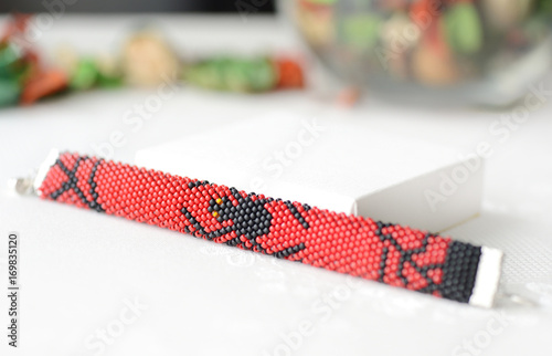 Halloween red bracelet with the image of black spider close up © Talulla