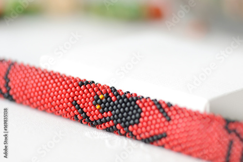 Halloween red bracelet with the image of black spider close up © Talulla