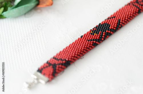 Halloween red bracelet with the image of black spider close up © Talulla