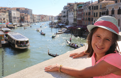 little girl above the Rialto bridge in Venice in Italy and the b