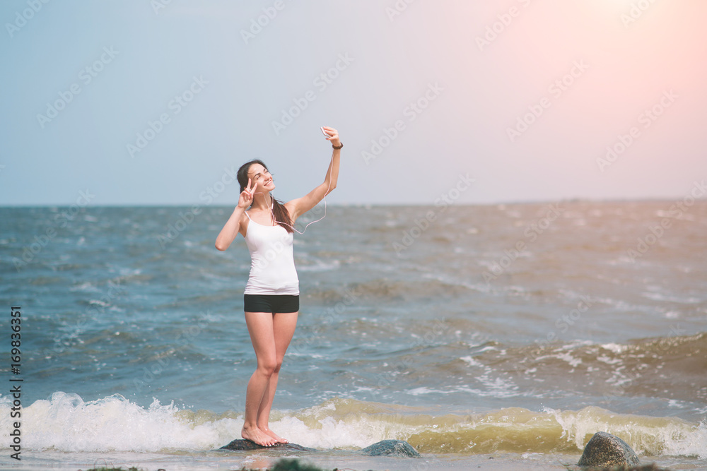 Fitness women exercising and stretching on the seacoast and making selfie Fitness women exercising and stretching on the seacoast and making selfie